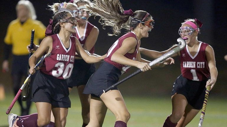 Garden City's Melanie McHugh, center, celebrates her game-winning goal with...