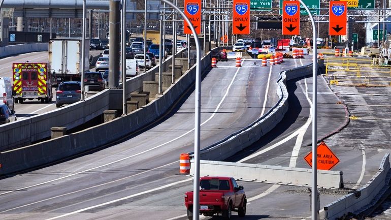 Diverted traffic passes a closed portion of the Washington Bridge,...