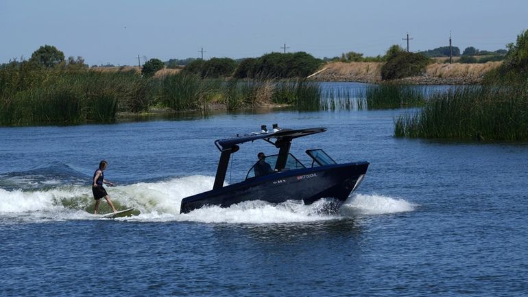 Grant Jeide wake surfs behind an electric sports boat made...