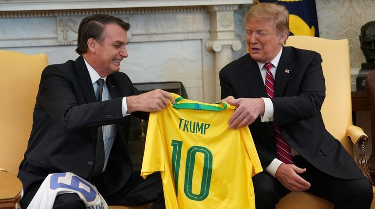 Brazilian President Jair Bolsonaro presents President Donald Trump with a...