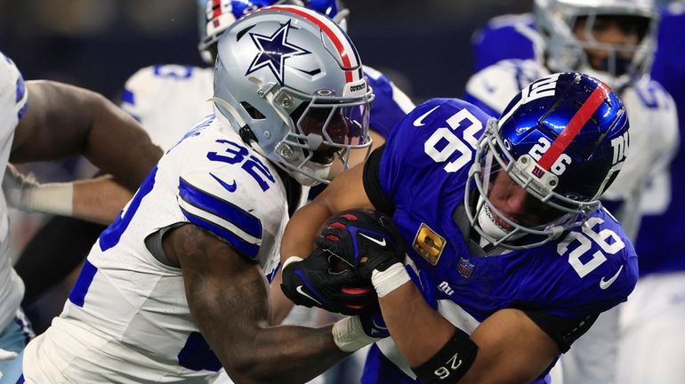 Saquon Barkley of the Giants wrestles for the ball against Rashaan Evans of...