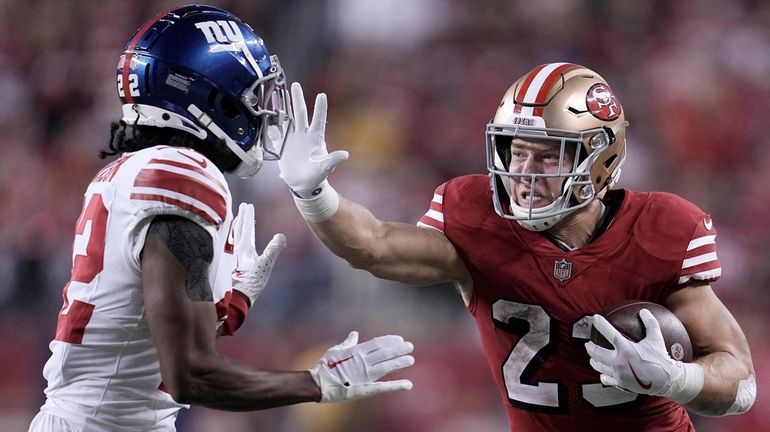 49ers running back Christian McCaffrey, right, runs against Giants cornerback Adoree'...