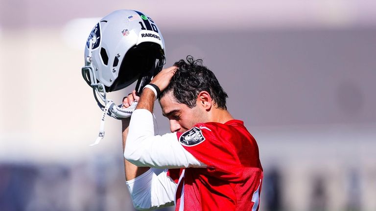 Las Vegas Raiders quarterback Jimmy Garoppolo (10) wipes away