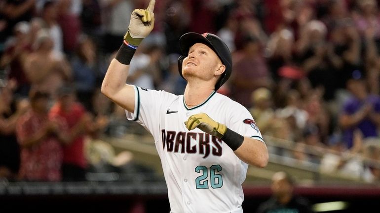 Arizona Diamondbacks' Pavin Smith points skyward after a three-run home...