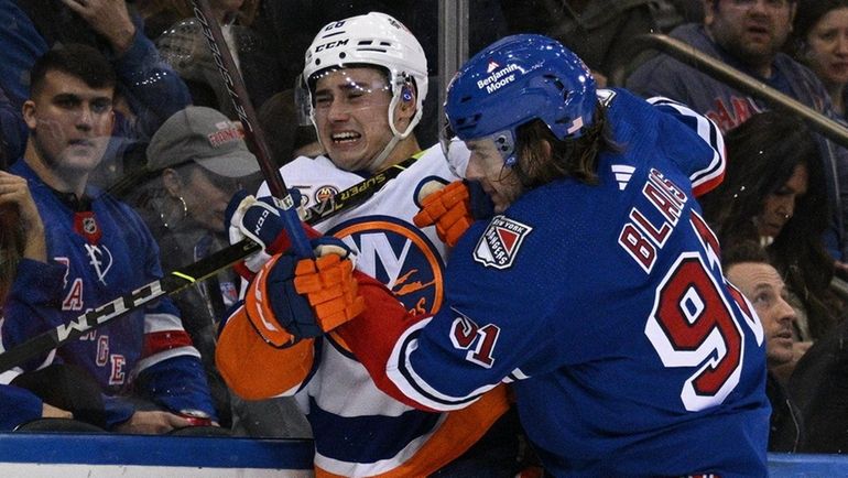 Rangers left wing Sammy Blais checks Islanders defenseman Alexander Romanov in...