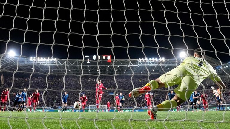 Liverpool's Mohamed Salah, center, scores the opening goal from the...