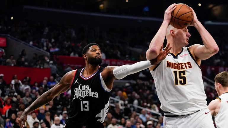 Los Angeles Clippers forward Paul George, left, defends against Denver...