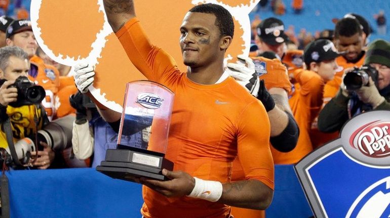 Clemson quarterback Deshaun Watson holds the most valuable player trophy...