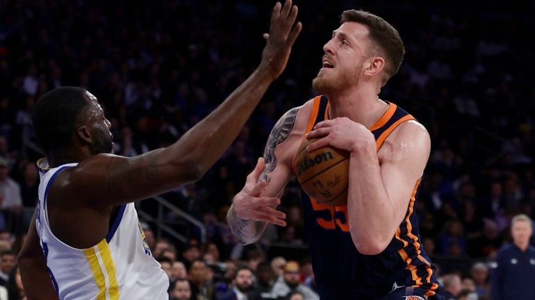 Isaiah Hartenstein of the Knicks commits an offensive foul against Draymond...