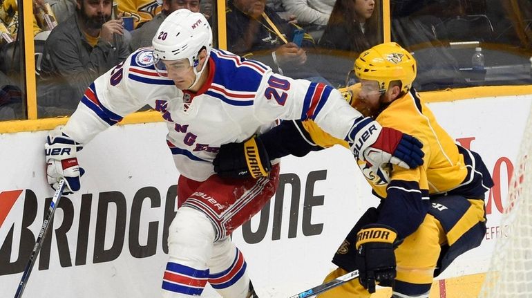 New York Rangers left wing Chris Kreider (20) fends off...