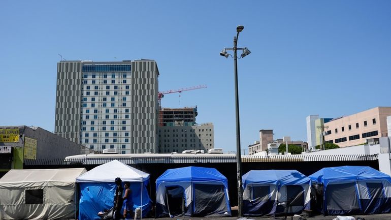 Tents are lined up on Skid Row Thursday, July 25,...