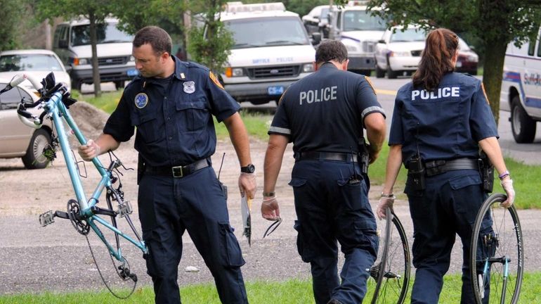 Police remove pieces of a bicycle near Patchogue Avenue in...