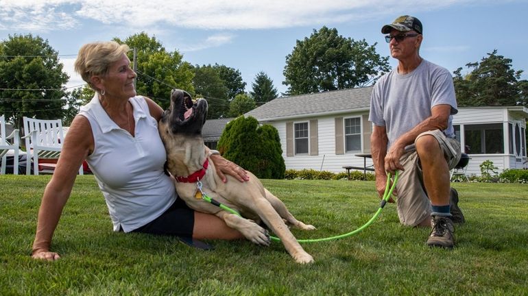 Roxi with her new owners, Sandy and John Reeve, at...