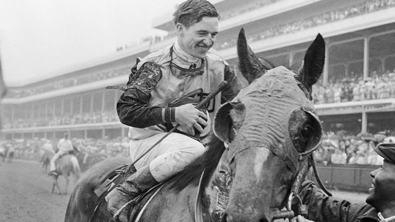 Jockey Bob Ussery sits atop Proud Clarion as they entered...