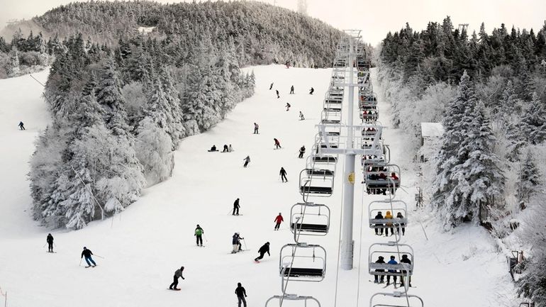 Thanksgiving holiday skiers descend near the North Ridge Quad chairlift,...