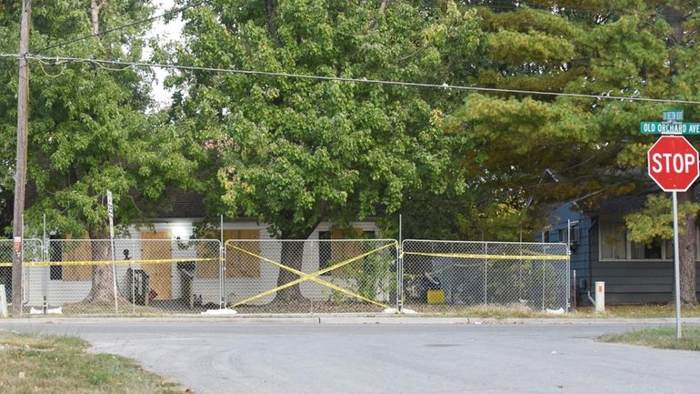 Police tape blocks the boarded-up residence of Timothy Haslett on...