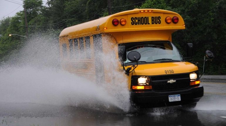 A school bus splashes through a large puddle along Yaphank-Middle...