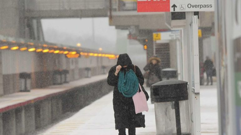 Commuters battle heavy snow and cold weather as they wait...