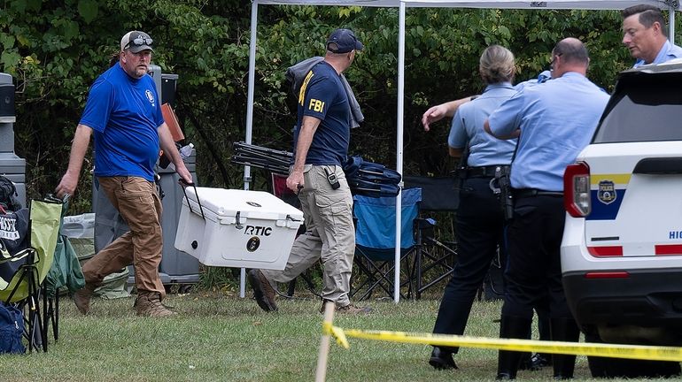 Philadelphia Police, FBI and forensic specialists work to exhume bodies...