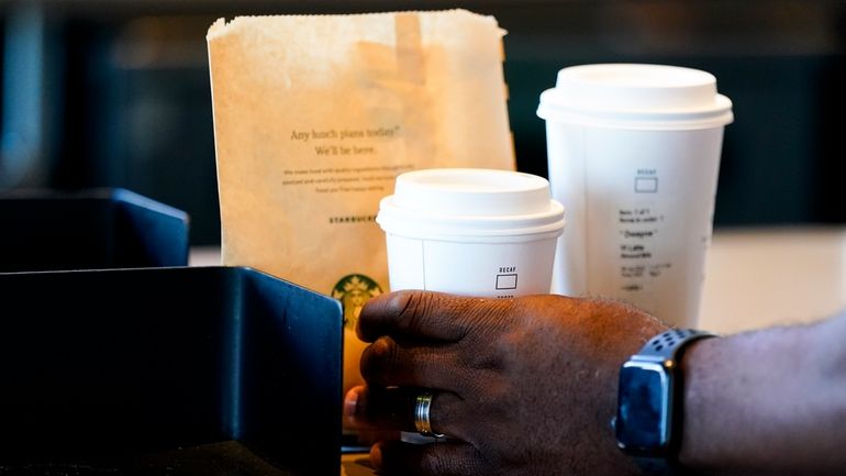 A customer picks up a drink at a Starbucks on...