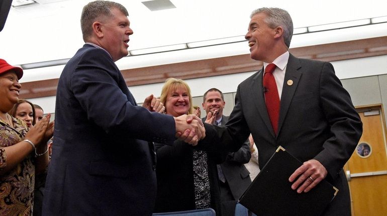 Suffolk County Executive Steve Bellone, right, is greeted by Town...