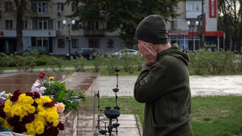 A servicewomen cries as she lays flowers to commemorate those...