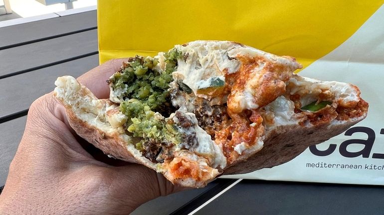 The O.G. Falafel Pita, here with hot sauce, at the...