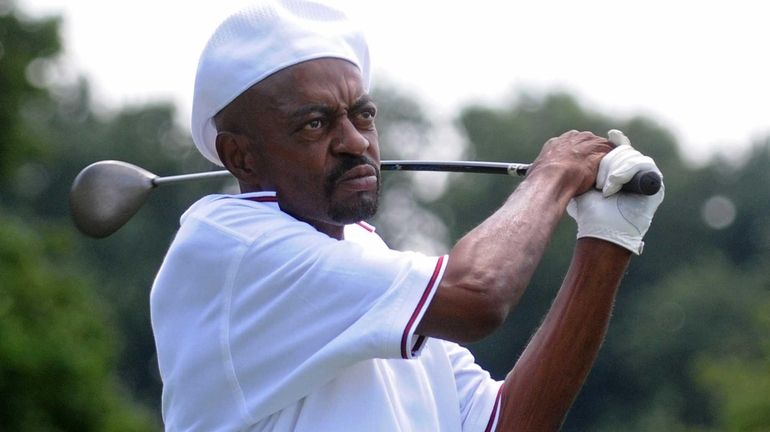 John Hankins, a caddie at Cherry Valley Club, tees off...