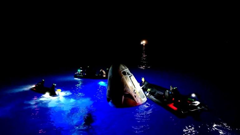 This image made from SpaceX video shows its capsule, center,...