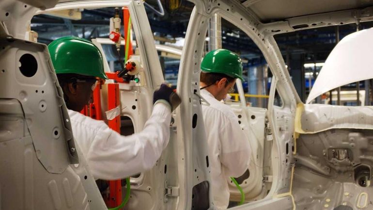 Workers at Honda's plant in Greensburg, Indiana remove a door...