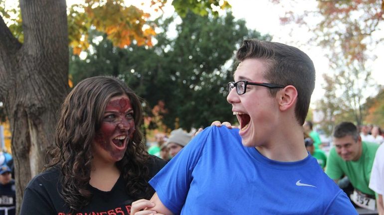 Kristina Fiakos, 16, of Massapequa, pretends to bite Michael Shelton,...