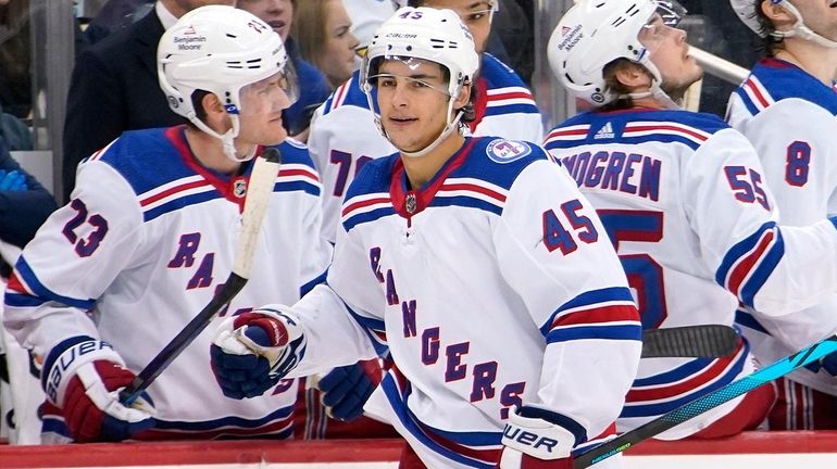 The Rangers' Braden Schneider returns the the bench after scoring...