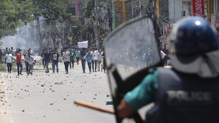 Students clash with riot police during a protest against a...