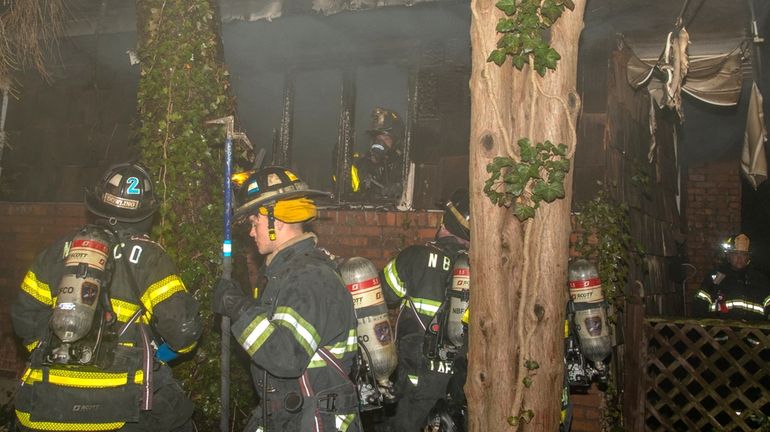 Firefighters at the scene of a fatal house fire on...