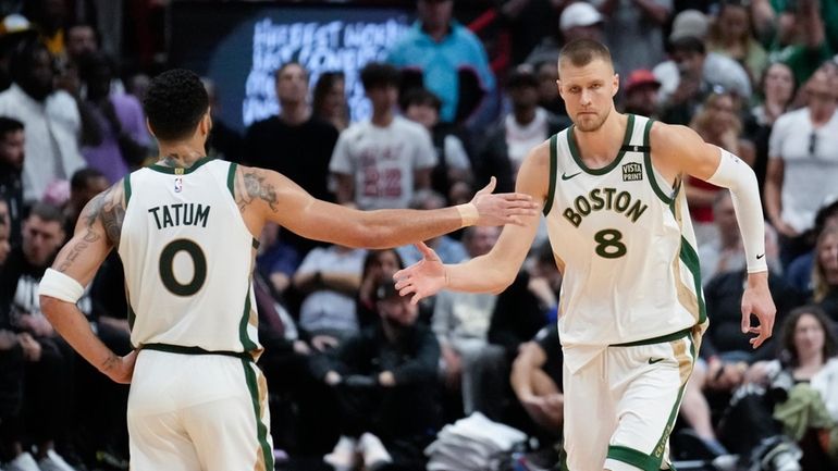 Boston Celtics center Kristaps Porzingis (8) celebrates with forward Jayson...