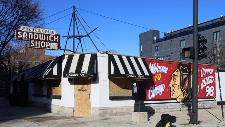 The windows of the Palace Grill is boarded up after...