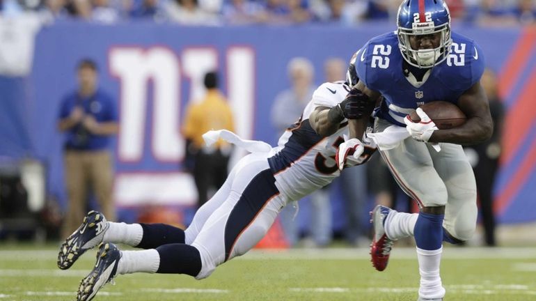 Denver Broncos' Duke Ihenacho tackles New York Giants' David Wilson...