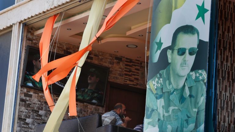 A poster shows Syrian President Bashar Assad installed at a...