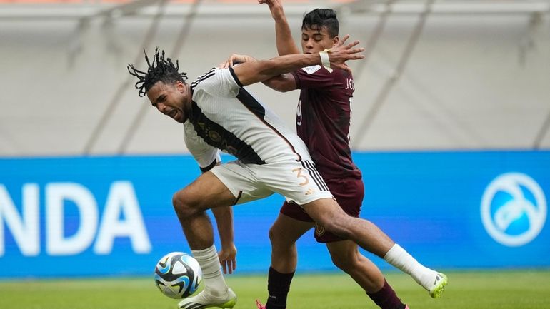 Germany's Almugera Kabar, left, battles for the ball against Venezuela's...