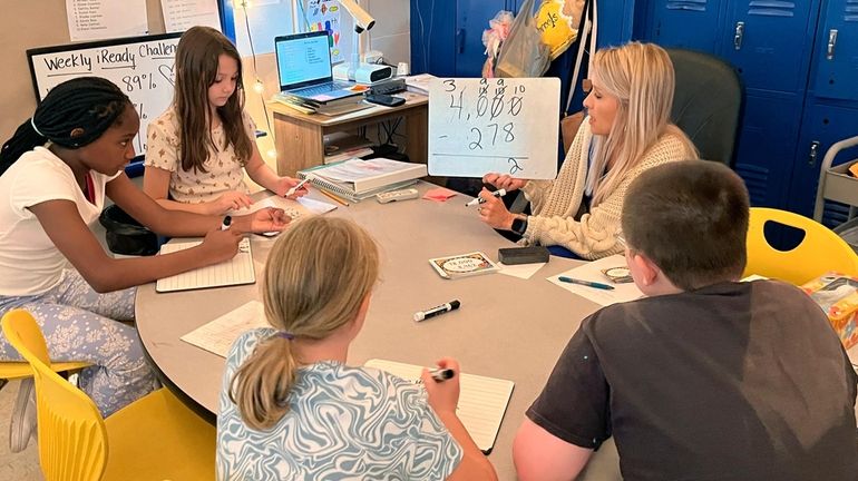 Piedmont Elementary School math teacher Cassie Holbrooks helps a small...