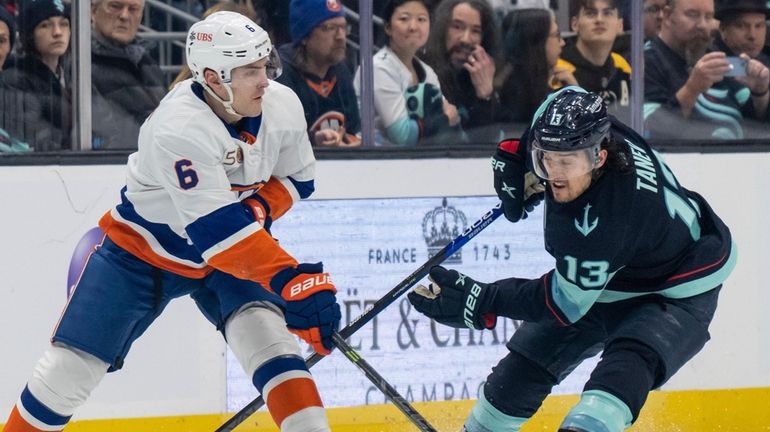 Islanders defenseman Ryan Pulock, left, and Kraken forward Brandon Tanev...