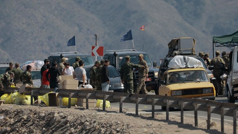 Ethnic Armenians from Nagorno-Karabakh and European Union observers drive their...