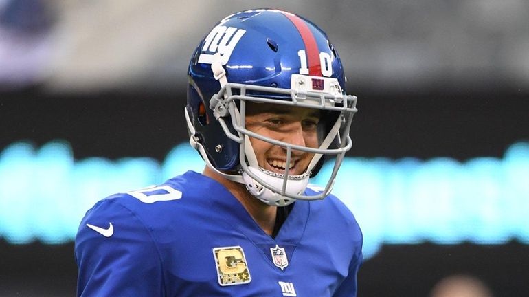 Giants quarterback Eli Manning warms up before a game against...