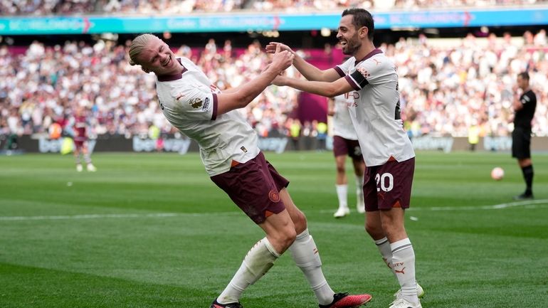 Manchester City's Erling Haaland, left, celebrates with Bernardo Silva after...