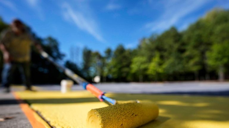 Ronnie Jefferies paints the parking lot at Science, Arts and...