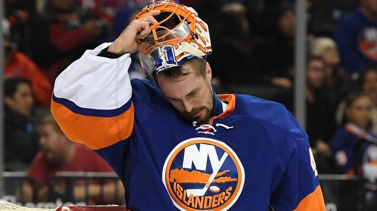 New York Islanders goalie Jaroslav Halak takes off his mask...