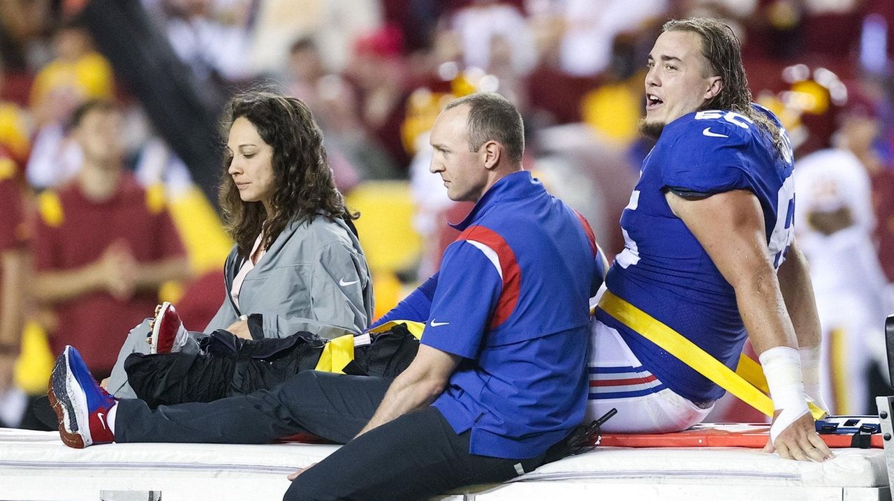 New York Giants center Nick Gates (65) lays on the field as members of the  team medical staff tend to him during the first half of an NFL football  game against the