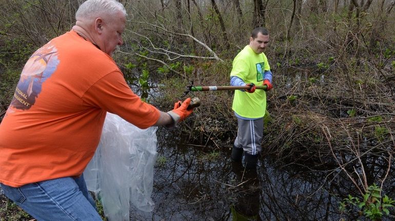 Greg McEnroe, left, and his son Timothy McEnroe help clean...