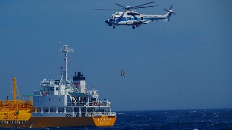 In this photo released by Japan Coast Guard, a woman...