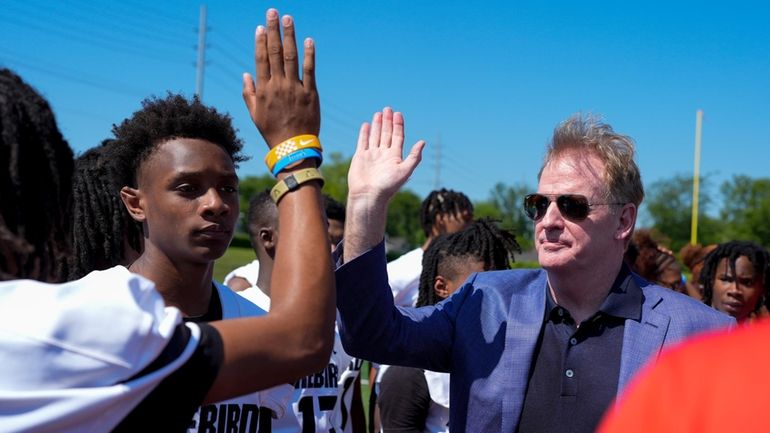 NFL Commissioner Roger Goodell hi-fives a Pearl-Cohn High School football...